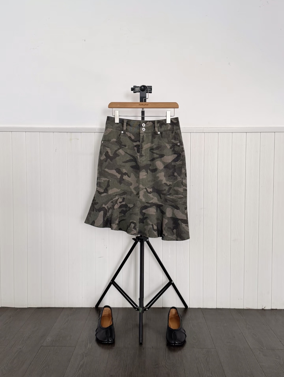 girl with a black compassionate printed tee on. She is wearing a silver mini skirt and a silver necklace